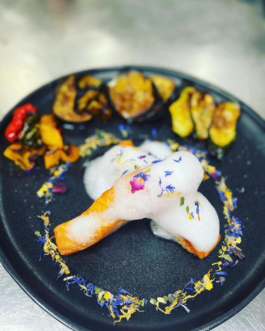 Salmone grigliato con Spuma al Limone mit gegrilltem Gemüse und Blüten